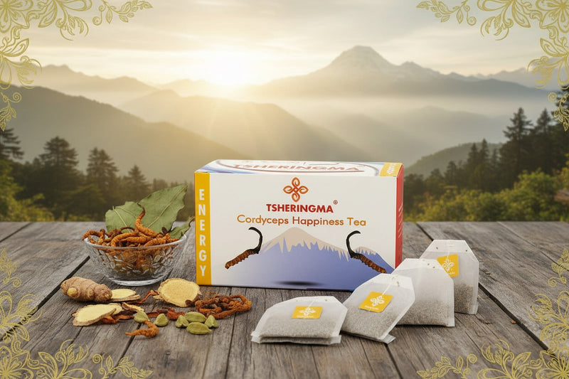 Tsheringma Cordyceps Happiness Tea packaging with tea bags and ingredients on a wooden surface with a mountainous background.